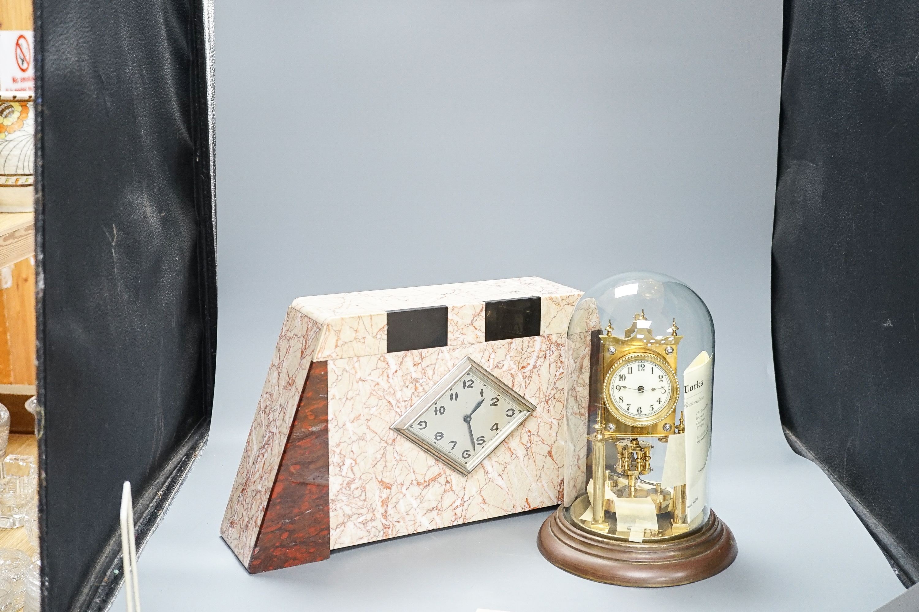 An Art Deco rouge marble mantel timepiece, 45cm wide, quartz movement replacement and a brass anniversary clock under glass dome